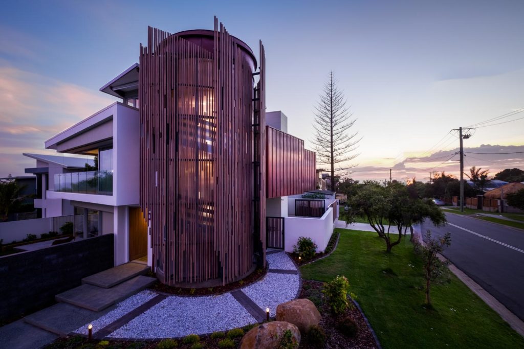 Seamless indoor-outdoor living in a Pottsville home by Create Architecture, with openable glass walls connecting the lounge to a covered patio and garden.